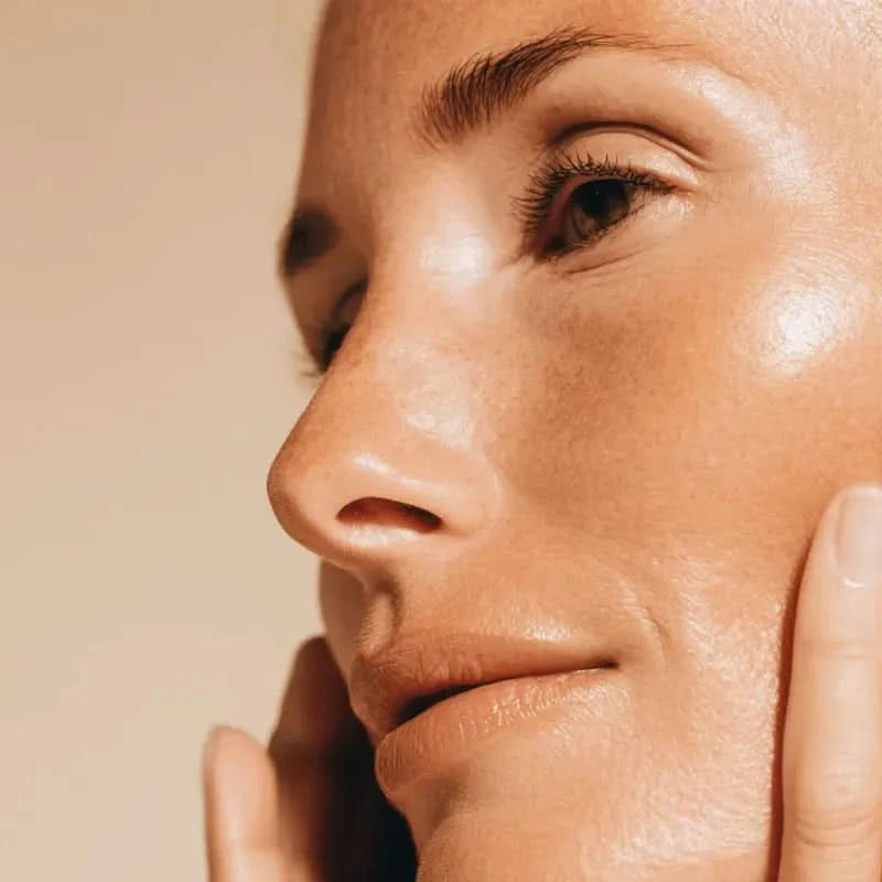 Close-up of a woman's face with glowing skin.